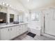 Bright bathroom with double sinks, tub, and glass-enclosed shower offering ample space and natural light at 9816 S Holland St, Littleton, CO 80127