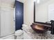 Modern bathroom featuring decorative vessel sink, granite countertop, dark accent wall, and glass-enclosed shower at 9816 S Holland St, Littleton, CO 80127