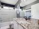 Charming bathroom with a soaking tub and shower, featuring granite countertops and modern fixtures at 9816 S Holland St, Littleton, CO 80127