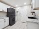 Well-equipped laundry room with stacked washer and dryer, granite countertops, white cabinets, and tile flooring at 9816 S Holland St, Littleton, CO 80127