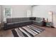 Living room featuring hardwood floors, large gray sofa, and bright light at 9816 S Holland St, Littleton, CO 80127