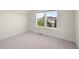 Bright bedroom featuring a large window and neutral carpet and paint at 10822 E 28Th Pl, Denver, CO 80238