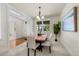 Bright dining room with wood table, six chairs, contemporary chandelier, neutral carpet, and serene artwork at 10822 E 28Th Pl, Denver, CO 80238