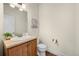 Cozy half-bathroom with wood cabinets, a neutral color scheme, and decorative accents at 10822 E 28Th Pl, Denver, CO 80238