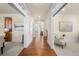 Bright hallway with hardwood floors, white trim, and views into adjacent living spaces at 10822 E 28Th Pl, Denver, CO 80238
