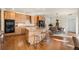 Spacious kitchen with wood cabinets, large island with seating, stainless steel appliances, and hardwood floors at 10822 E 28Th Pl, Denver, CO 80238