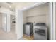 Laundry room with modern stainless steel washer and dryer units, lots of light, and extra shelving at 10822 E 28Th Pl, Denver, CO 80238
