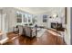 Sunlit living room with large windows, fireplace, hardwood floors, and stylish furnishings for comfortable living at 10822 E 28Th Pl, Denver, CO 80238