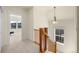 Carpeted staircase with a wooden railing, lots of natural light, and access to the upper level at 10822 E 28Th Pl, Denver, CO 80238