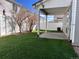 A fenced backyard featuring a well-maintained lawn and a covered patio for outdoor relaxation and entertaining at 5566 Flanders St, Denver, CO 80249