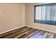 Bedroom featuring wood-look flooring, neutral walls, and natural light from a window at 5566 Flanders St, Denver, CO 80249
