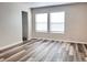 Bright bedroom featuring wood-look flooring, neutral walls, and natural light from windows at 5566 Flanders St, Denver, CO 80249