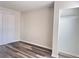 Bedroom featuring wood-look flooring, neutral walls, closet and natural light from a sliding glass door at 5566 Flanders St, Denver, CO 80249