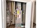 Utility closet with water heater, gas furnace, and HVAC in closet with open doors at 5566 Flanders St, Denver, CO 80249