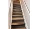 Stairway featuring modern wood treads and a white railing, offering a seamless transition between levels of the home at 5566 Flanders St, Denver, CO 80249
