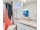 Modern bathroom featuring stylish shower curtain, vanity with granite countertop, and natural light at 4390 Osage St, Denver, CO 80211