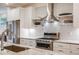 Close-up of modern kitchen showcasing stainless steel appliances, white cabinets, and tile backsplash at 4390 Osage St, Denver, CO 80211