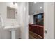 Modern powder room boasting a pedestal sink and a view into the adjacent cozy living space at 4390 Osage St, Denver, CO 80211