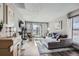 Bright living room with a gray sectional sofa, wood floors, and sliding glass doors to a balcony at 2740 W 86Th Ave # 190, Westminster, CO 80031