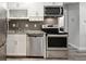 Updated kitchen features stainless steel appliances, tile backsplash, and granite countertops at 5875 E Iliff Ave # 108, Denver, CO 80222