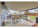 Covered back porch with wooden flooring, seating, and a spacious fenced yard at 4533 S Devinney St, Morrison, CO 80465