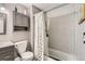 Bathroom with gray vanity, shower and tub with gray tiled walls, toilet and toiletry storage at 4533 S Devinney St, Morrison, CO 80465