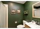 Bathroom with green painted walls, framed art, and modern vanity with updated fixtures and shower at 9786 Malachite Ct, Parker, CO 80134