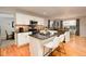 Bright kitchen featuring an island, granite countertops, modern appliances, and hardwood floors at 9786 Malachite Ct, Parker, CO 80134