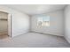 Bright bedroom showcasing neutral carpet, a window view, and a door leading to closet space at 1401 Bloom St, Brighton, CO 80601