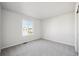 Bright bedroom featuring neutral carpet, white walls, and a window providing natural light at 1401 Bloom St, Brighton, CO 80601