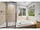 Bright bathroom featuring a glass-enclosed shower, soaking tub and large windows offering natural light at 2732 Flint Ct, Superior, CO 80027