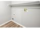 A simple laundry room with light wood-look floors, utility connections, and overhead shelf at 2732 Flint Ct, Superior, CO 80027