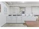 Clean laundry room with multiple white washers and dryers against white brick walls at 1356 N Pearl St # 202, Denver, CO 80203