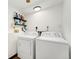 Bright laundry room featuring a stacked washer and dryer, convenient shelving, and a clean, organized space at 13388 Alcott Cir, Broomfield, CO 80020