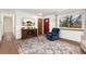 Bright living room featuring hardwood floors, a TV, and a comfortable blue armchair near a window at 13388 Alcott Cir, Broomfield, CO 80020