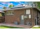 The back exterior of the brick home features solar panels, a door, and an AC unit at 2271 Holly St, Denver, CO 80207