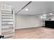 A finished basement with new flooring, stairs, a fireplace, and built-in bookshelves at 2271 Holly St, Denver, CO 80207
