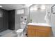 Well-lit bathroom with a modern vanity, dark tiled shower, and decorative artwork at 2271 Holly St, Denver, CO 80207