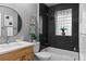 Modern bathroom features a vanity, black tile, glass block window and combined tub and shower at 2271 Holly St, Denver, CO 80207