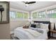 Bright bedroom with large windows, ceiling fan, and a beautifully decorated queen bed at 2271 Holly St, Denver, CO 80207