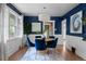 Stylish dining room features blue walls, white wainscoting, and round table with plush blue chairs at 2271 Holly St, Denver, CO 80207