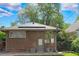 Brick home exterior featuring solar panels, a back entrance, and established trees at 2271 Holly St, Denver, CO 80207