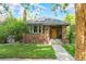 Charming brick home with manicured lawn, sidewalk, and stylish wood front door at 2271 Holly St, Denver, CO 80207