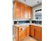 Well-appointed kitchen features wood cabinets, granite countertops, and stainless steel appliances, under a window at 2271 Holly St, Denver, CO 80207