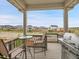 Covered balcony with a dining table and grill overlooking the street and neighborhood at 4552 S Perth Ct, Aurora, CO 80015