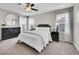 Bright bedroom with a plush bed, round mirror, and dark dresser at 4552 S Perth Ct, Aurora, CO 80015
