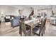 A dining room blends into a living room, featuring a wooden table and chairs with decor at 4552 S Perth Ct, Aurora, CO 80015