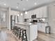 Modern kitchen featuring white cabinets, a large island with seating, and stainless steel appliances at 4552 S Perth Ct, Aurora, CO 80015