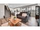 Open-concept living room with stairs to a kitchen and dining area with elegant furniture at 4552 S Perth Ct, Aurora, CO 80015
