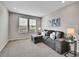 Cozy living room features a gray sectional sofa, plush carpet, and bright natural light at 4552 S Perth Ct, Aurora, CO 80015